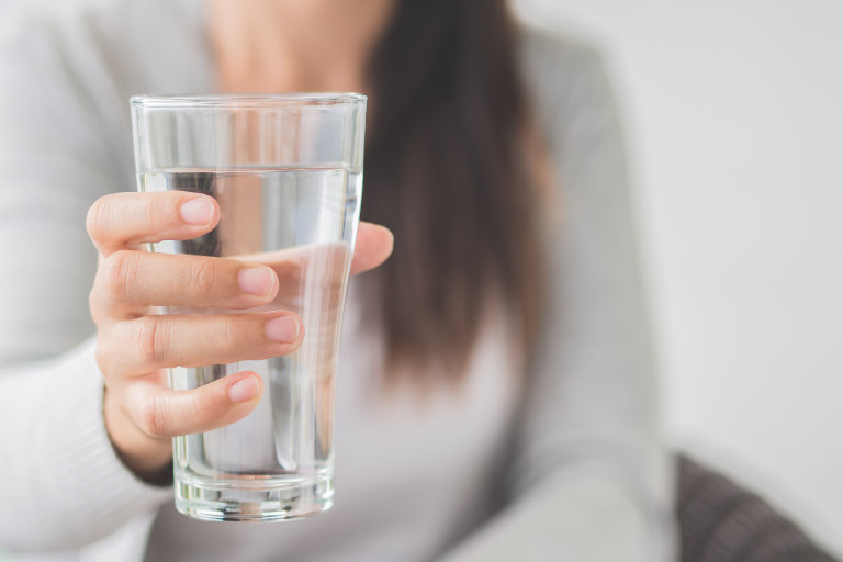 woman holding up glass of water