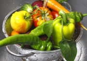 fresh vegetables in colander under water